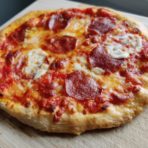 Nygräddad pizza med gyllene ost, krispig botten