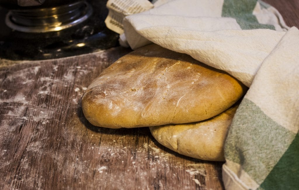 Lättbakad hönökaka nybakad på träbräda med mjöl och kökshandduk