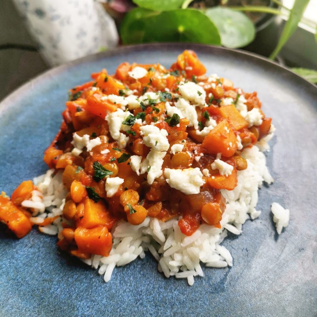 Linsgryta med sötpotatis toppad med fetaost serverad på jasminris