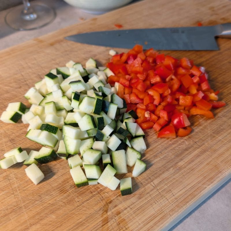 Hackad zuccini och paprika på en skärbräda Medelhav medelhavslax med bulgur Hackad Zucchini och Paprika på en skärbräda